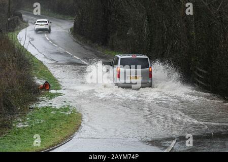 Buckfastleigh, Devon, Royaume-Uni. 16 février 2020. Météo britannique. Une voiture conduit par l'eau d'inondation de la forte pluie de Storm Dennis sur l'A384 près de Buckfastleigh à Devon. Crédit Photo : Graham Hunt/Alay Live News Banque D'Images