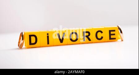 Texte de divorce sur bloc plastique et anneaux de mariage Banque D'Images