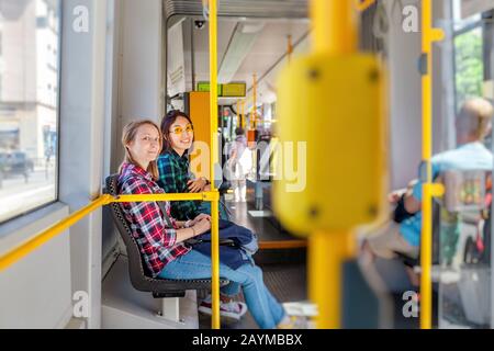 Deux jeunes filles souriantes souriant à l'intérieur du tram Banque D'Images