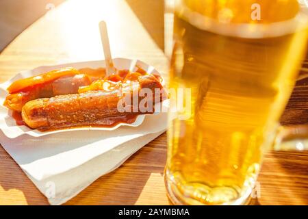 Curry wurst saucisses avec bière sur la table dans le restaurant extérieur Banque D'Images