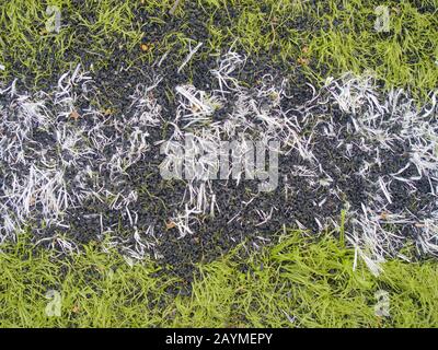 Base caoutchouteuse de gazon de football. Terrain de football vert synthétique à gazon artificiel avec ligne à rayures blanches Banque D'Images