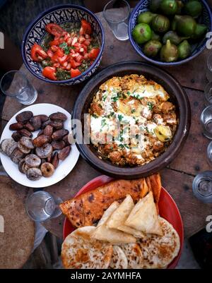 Plats traditionnels marocains Tajine, salade marocaine, pain et fruits secs sur la table. Vue en grand angle sur un repas marocain réaliste. Banque D'Images