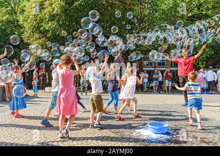 12 MAI 2018, SLOVAQUIE, BRATISLAVA: Un artiste de rue fait un spectacle de bulle de savon pour que les enfants reçoivent des dons de leurs parents Banque D'Images