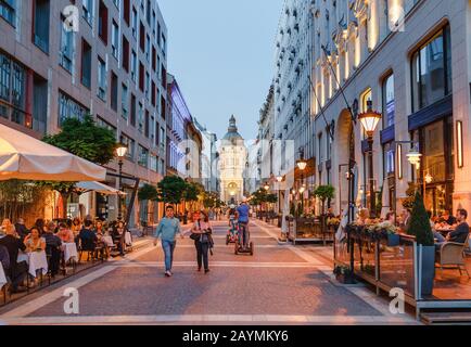 13 MAI 2018, BUDAPEST, HONGRIE : rue Zrinyi avec vue sur les gens et la cathédrale de Stephen en soirée Banque D'Images