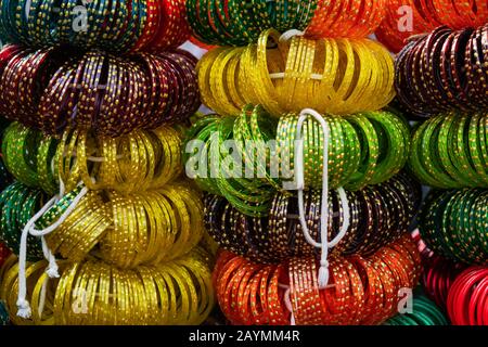 Des bangles de verre indiens dans des couleurs vives étant vendus le long de la rue ouverte à Udaipur, Rajasthan, Inde. Banque D'Images