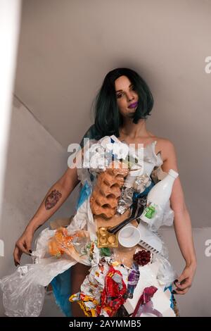Portrait d'une femme souillée écofighter portant une robe à ordures en plastique et en carton pour favoriser la propagation de la nature de nettoyage de l'environnement par la pollution Banque D'Images