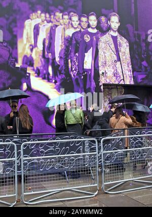 Les personnes qui tiennent des parasols à l'extérieur du Showall du BFC pendant la semaine de la mode de Londres automne/hiver 2020. Banque D'Images