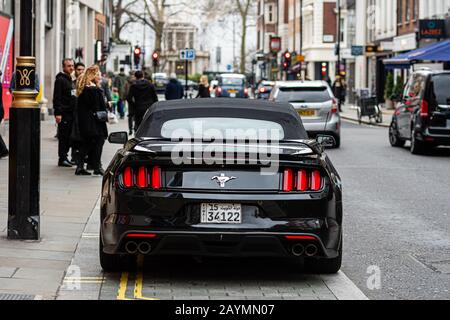 Londres, Angleterre, Royaume-Uni - 2 janvier 2020: Une voiture de muscle sportif noire et coûteuse garée au bord d'une rue de la ville Banque D'Images