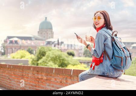 Mode heureuse jeune voyageur femme utilisant smartphone avec tasse de café, étudiant et indépendant concept d'affaires Banque D'Images