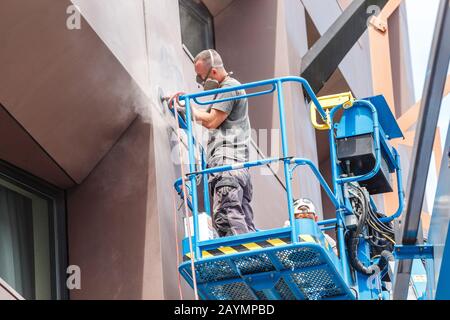 14 MAI 2018, BUDAPEST, HONGRIE: Travailleurs de la construction dans un seau de véhicule de grue pour la restauration et la réparation de la façade du bâtiment Banque D'Images