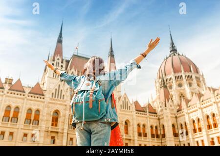 Une heureuse étudiante asiatique décontractée en femme bénéficiant d'une vue imprenable sur le bâtiment du Parlement à Budapest, voyage en Europe concept Banque D'Images