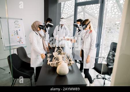 science, technologie, réalité virtuelle et concept de personnes. Professeur avec groupe d'étudiants en médecine multiethnique utilisant des lunettes de réalité virtuelle pour l'examen Banque D'Images
