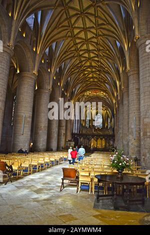 L'abbaye de Sainte Marie la Vierge, connue sous le nom d'abbaye de Tewkesbury. Vue intérieure de la nef avec colonnes en pierre et plafond voûté. Fenêtres de bureau. Banque D'Images