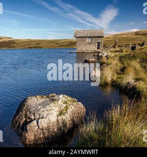 La vieille maison en pierre désaffecte sur les rives de l'eau de Devoke, Lake District National Park, Cumbria, Angleterre, Royaume-Uni Banque D'Images