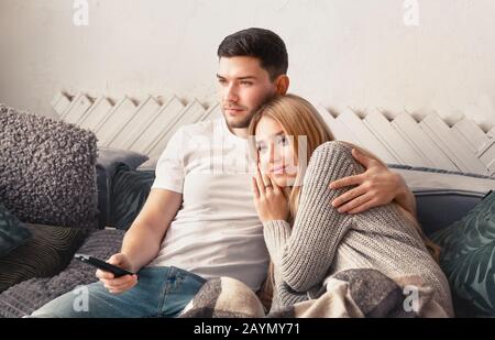 Un couple heureux adorant regarder la télévision sur le canapé à la maison Banque D'Images