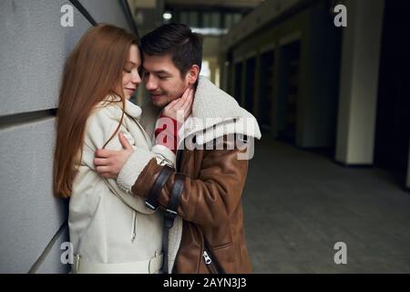 Jeune couple souriant heureux séduisant embrassant dans la rue, tendresse, affection, amour, sentiment positif et émotion. Amour esentiel. Espace de copie. CLO Banque D'Images
