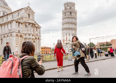 16 OCTOBRE 2018, PISA, ITALIE : foules de touristes faisant des poses drôles devant la célèbre tour penchée de Pise Banque D'Images