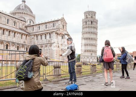 16 OCTOBRE 2018, PISA, ITALIE : foules de touristes faisant des poses drôles devant la célèbre tour penchée de Pise Banque D'Images