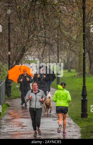 Londres, Royaume-Uni. 16 février 2020. L'exercice, les chiens de marche et le jogging continuent, et les wellies sont à l'ordre du jour, même pour les joggers - Storm Dennis apporte de la pluie et du vent lourds à Clapham pour un deuxième week-end dans une rangée. Crédit: Guy Bell/Alay Live News Banque D'Images