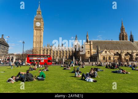 Les gens se détendre dans Parliament Square, London, England, UK Banque D'Images