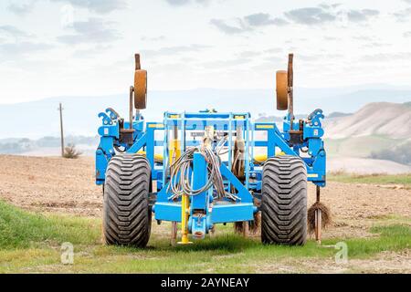 Charrue lourde et cultivateur modernes debout sur un terrain en Toscane, concept agricole et machines Banque D'Images