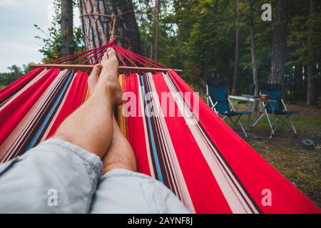 homme se reposant sur un hamac en temps d'été forestier Banque D'Images