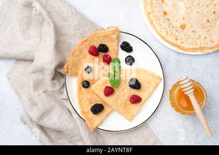 Crêpes Françaises Avec Baies D'Été Et Miel Sur Plaque. Vue Du Dessus De La Table. Délicieux Petit Déjeuner Sucré Banque D'Images