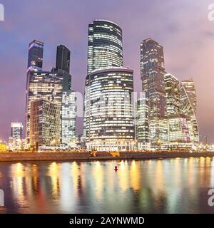 Gratte-ciel illuminés à Moscou City ou centre d'affaires international la nuit avec lumières, vue de la bankment de l'étang d'eau avec des reflets Banque D'Images