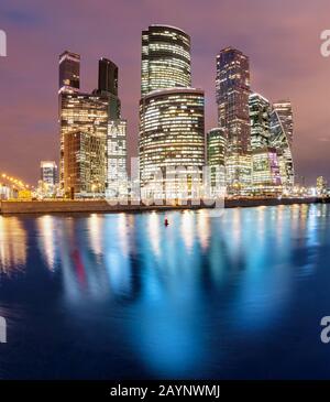 Gratte-ciel illuminés à Moscou City ou centre d'affaires international la nuit avec lumières, vue de la bankment de l'étang d'eau avec des reflets Banque D'Images