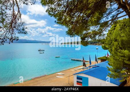 Zlatni Rat Beach, Golden Horn ou Golden Cape dans la ville de bol, île de Brac, Croatie. Plage de gravier, pins, bateaux et eaux turquoise de la mer Adriatique sur Banque D'Images