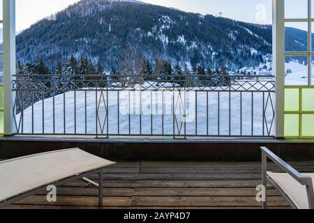 Chaise de détente sur un balcon avec vue sur la chaîne de montagnes de Davos sur la montagne suisse le jour d'hiver. Banque D'Images