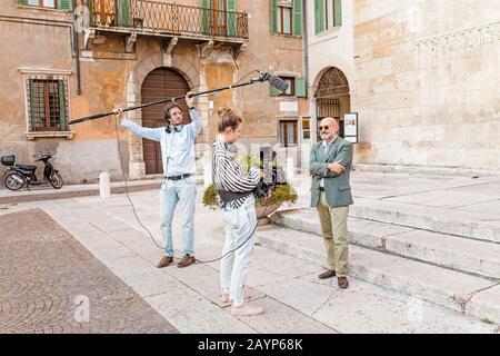 20 OCTOBRE 2018, VÉRONE, ITALIE: Caméraman professionnel et journaliste interviewer l'homme à l'extérieur Banque D'Images