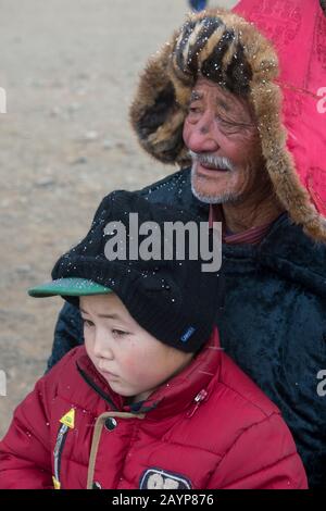 Portrait d'un homme kazakh avec un petit-fils au Golden Eagle Festival près de la ville d'Ulgii (Ölgii) dans la province de Bayan-Ulgii dans l'ouest de la Mongolie. Banque D'Images