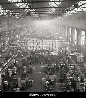 Années 1950, historique, une vue de dessus regardant sur les ouvriers et les machines sur le plancher de production du bâtiment industriel rempli de lumière abritant une partie du complexe de fabrication de la société de batteries Ever Ready, Forest Rd, Walthamstow, East London, E17, Angleterre, Royaume-Uni. Le site géant a été ouvert en 1933 dans les anciens locaux des constructeurs de bus et de camions Britsh, Associated Equipment Company (AEC). Banque D'Images