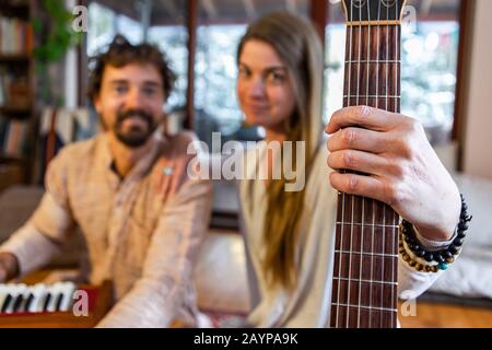 Gros plan de femme chamanique tenant de la guitare classique avec l'homme jouant l'harmonium d'instrument de musique comme musique sacrée et kirtan Banque D'Images