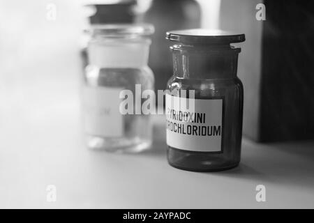 Flacons à médicaments anciens avec produits chimiques de pyridoxine sur le plateau de la pharmacie. Flacons et verrerie de laboratoire chimiques pour tests scientifiques. Médecine de pharmacie Banque D'Images