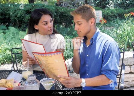 Austin, Texas : un couple hispanique de la vingtaine a lu le menu sur le patio extérieur du restaurant. ©Bob Daemmrich Banque D'Images