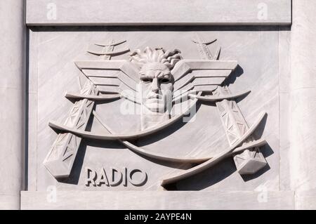 Bas-relief dans le style fasciste représentant le service télégraphique, sur la façade du bureau central de poste à Carrara, Italie. Banque D'Images