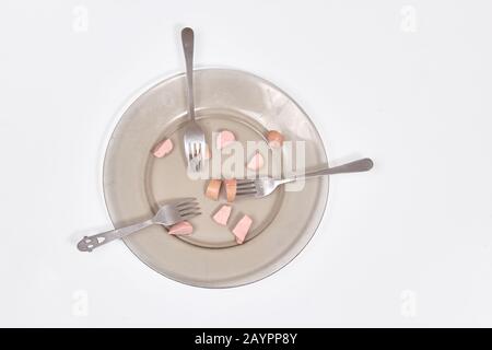 Saucisses dans une plaque coupée en morceaux sur un fond clair vue de dessus Banque D'Images