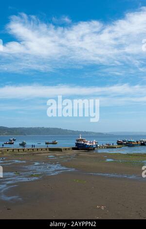 Vue sur la jetée du village d'Achao sur l'île de Quinchao, île de Chiloe dans le sud du Chili à marée basse. Banque D'Images