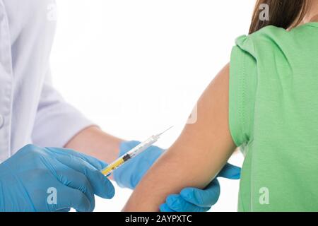 Vue rognée du pédiatre faisant l'injection avec le vaccin à l'enfant isolé sur blanc