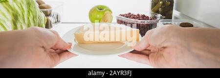 Vue rognée d'une femme prenant du fromage du réfrigérateur avec des aliments isolés sur blanc, photo panoramique, image de stock Banque D'Images