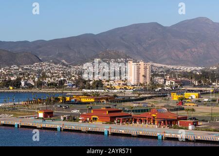 Ensenada, Mexique - 17 janvier 2012: Fermeture du terminal de croisière Rouge à l'embarcadère du port avec vue sur la ville sur la pente de la montagne à l'arrière et derrière la baie bleue Banque D'Images