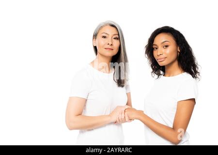 des femmes africaines attrayantes, américaines et asiatiques, se tenant les mains isolées sur le blanc Banque D'Images