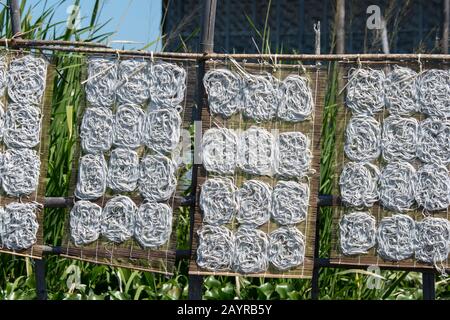 Les nouilles s'assèchent au soleil dans un village sur pilotis dans le lac Inle au Myanmar. Banque D'Images