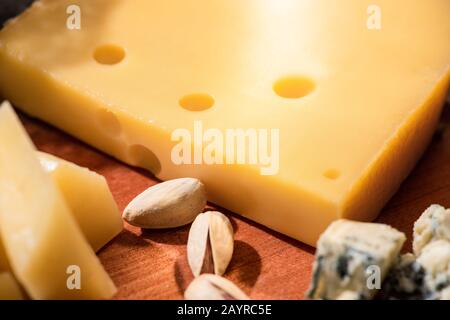 Foyer sélectif de différents types de fromage avec des pistaches sur fond de bois Banque D'Images