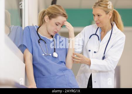 infirmière femme stressée tenant la tête Banque D'Images