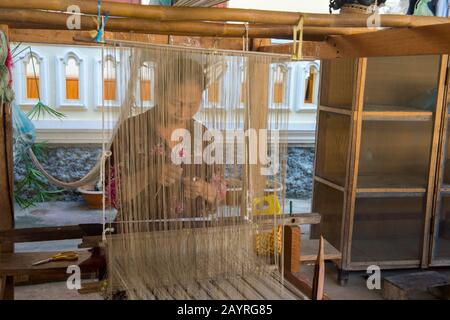 Une femme sur un métier à tisser serpente la soie et les tissus de coton lors d'un atelier à Ban Xang Khong, un village près de Luang Prabang au Laos central, qui est connu pour Banque D'Images