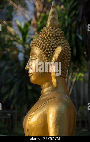 Détail d'une statue de Bouddha guildée à Wat Xieng Muan (Xieng Muan Vajiramangalaram) un temple bouddhiste dans la ville du patrimoine mondial de l'UNESCO de Luang Prabang Banque D'Images