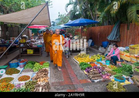 Une scène du marché du début de la matinée avec des moines bouddhistes dans la ville du patrimoine mondial de l'UNESCO de Luang Prabang au Laos central. Banque D'Images